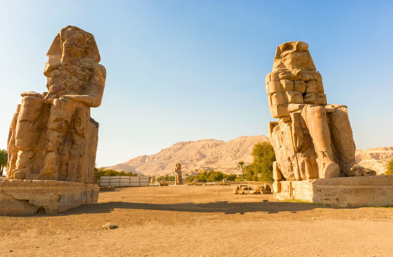 In The Desert, The Colossi Of Memnon Feature Two Impressive Pharaoh Statues, Symbolizing Ancient Egyptian Grandeur